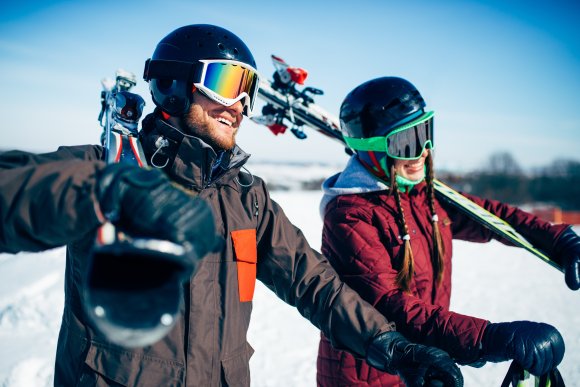 Male and female skiers poses with skis and poles